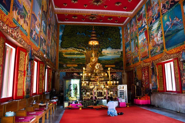 Tayland 'ın başkenti Nonthaburi' de 17 Mart 2022 'de Wat Chomphuwek ya da Chumpoo Wek tapınağındaki eski Ubosot kilisesinde gezginler için antik Buda heykelleri ziyaret eder ve dua eder.