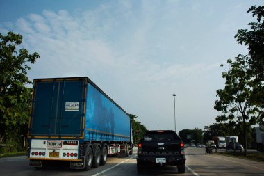 Tayland 'ın Phatthalung kentinde 13 Nisan 2022' de Phet Kasem karayolu üzerinde motosiklet ve araç kullanan gezginlerle trafik ışığı kavşağı.