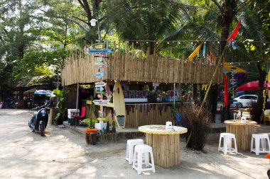 Sahil kenarındaki bambu kafe ve restoran restoranı servis için Tayland 'a seyahat bekleyen gezginler 12 Nisan 2022' de Satun, Tayland 'da bulunan Pak Bara' da Prasat Hin Pan Yod 'u ziyaret ediyor.