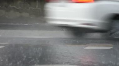 Tayland 'ın Nonthaburi kentindeki Bangbuathong şehrinde sağanak yağış yağarken Taylandlı insanların bisiklet sürdüğü kırsal ve trafik yollarını gözleyin.