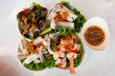 Taylandlı Pak Bara, Satun 'daki restoran kafeteryasında müşteriler için baharatlı ekşi soslu sebze ve modern seramik tabakta kaynatılmış çeşitli deniz ürünleri.