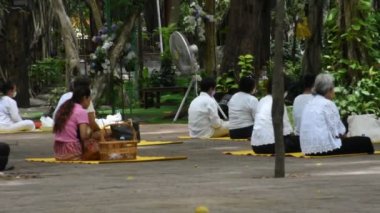 Taylandlılar dini törenlere katılıyor ve meditasyon yapıyor. Buda 'yla birlikte dua ediyor ve Tayland, Nonthaburi' deki Wat Sangkhatan Tapınağı 'ndaki meditasyon parkında kutsal ibadeti kutsuyorlar.