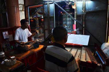 Çin asıllı Taylandlılar, geleneksel Çin modern klasik operasını icra etmek için 13 Mart 2011 'de Bangkok Tayland' daki festivalde şarkı söylüyorlar.