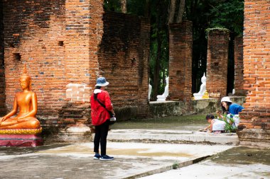 Tayland 'ın Chai Nat kentindeki Chainat şehrindeki Wat Phra Kaew tapınağının kutsal gizemine dua ederek seyahat eden Taylandlılar için antik antik beyaz Buda heykeli ubosot harabesi.