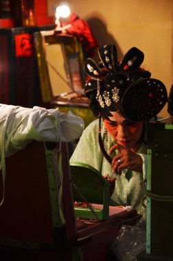 13 Mart 2011 'de Bangkok Tayland' da geleneksel Çin klasik operasını canlandırmak için Çin kökenli makyajcı insanların yüzlerine makyaj yapıp antik oyunculuk kıyafetleri giymeleri gerekiyor.