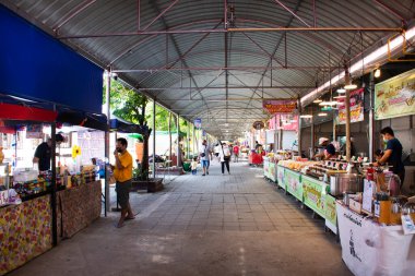 Taylandlı gezginler 12 Haziran 2022 'de Nonthaburi, Tayland' da bulunan Pak Kret şehrindeki Wat Bang Chak tapınağındaki yerel market marketinde alışveriş içecekleri ve hediyelik eşya dükkanlarını ziyaret ediyorlar.
