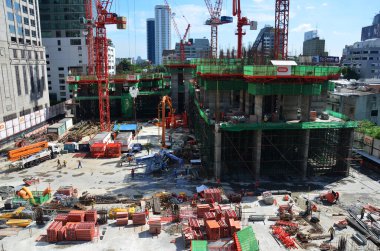 Asyalı işçiler ve Taylandlı işçiler, Bangkok, Tayland 'daki başkentte yapı iskelesi inşaatında makine ve ağır makineler kullanıyorlar.