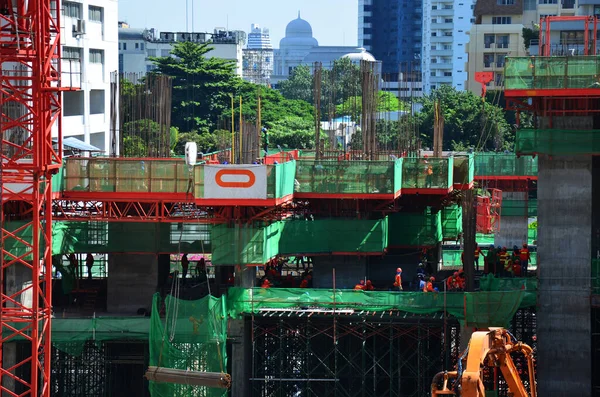 Asian labor people and thai labour workers use machine and heavy machinery working builder new building tower at construction site high-rise building on scaffold at capital city in Bangkok, Thailand