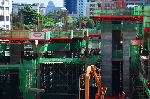 Asian labor people and thai labour workers use machine and heavy machinery working builder new building tower at construction site high-rise building on scaffold at capital city in Bangkok, Thailand