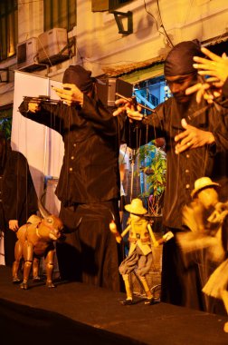 Taylandlı profesyonel kuklacı ya da kukla ustası 22 Mayıs 2011 'de Bangkok Tayland' da SamYan 'da düzenlenen gece festivali etkinliği için eski kukla oyuncakları ya da antika kuklaları oynuyor.