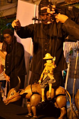 Taylandlı profesyonel kuklacı ya da kukla ustası 22 Mayıs 2011 'de Bangkok Tayland' da SamYan 'da düzenlenen gece festivali etkinliği için eski kukla oyuncakları ya da antika kuklaları oynuyor.
