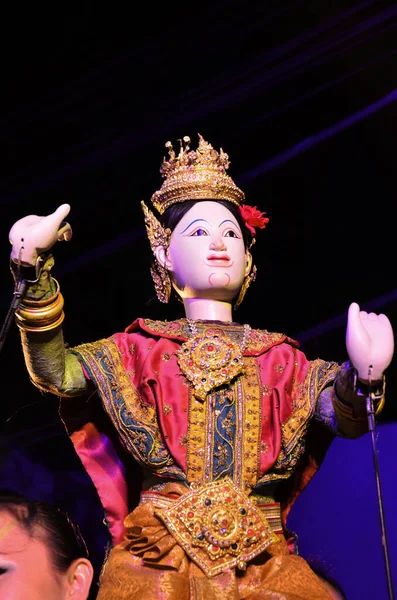 Thai professional puppeteer or Puppet master manipulate playing acting ancient puppets toy or antique marionette on stage show travelers people in night festival event at Sam Yan in Bangkok, Thailand