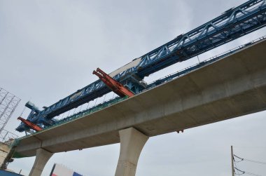 Asian labor people and thai labour worker use machine and heavy machinery working builder railway track electric sky train at construction site building on scaffold at capital city in Bangkok Thailand