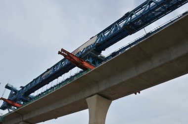Asian labor people and thai labour worker use machine and heavy machinery working builder railway track electric sky train at construction site building on scaffold at capital city in Bangkok Thailand