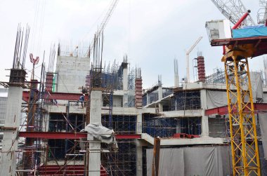 Asian labor people and thai labour worker use machine and heavy machinery working builder railway track electric sky train at construction site building on scaffold at capital city in Bangkok Thailand