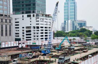 Asian labor people and thai labour worker use machine and heavy machinery working builder railway track electric sky train at construction site building on scaffold at capital city in Bangkok Thailand