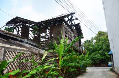 Exterior structure broken damaged of outdoor abandoned wooden antique building from old wood house fire at village in Bangkok, Thailand