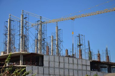 Asian labor people and thai labour workers use machine and heavy machinery working builder new structure tower high-rise building on scaffold at construction site at capital city in Bangkok, Thailand