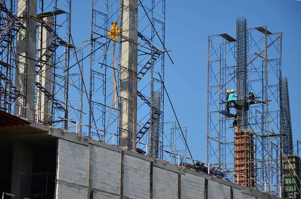 Asian labor people and thai labour workers use machine and heavy machinery working builder new structure tower high-rise building on scaffold at construction site at capital city in Bangkok, Thailand