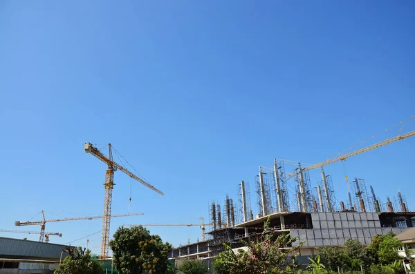 Asian labor people and thai labour workers use machine and heavy machinery working builder new structure tower high-rise building on scaffold at construction site at capital city in Bangkok, Thailand