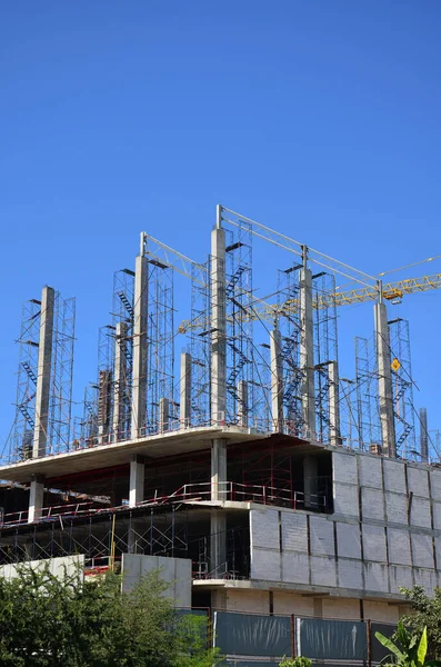 Asian labor people and thai labour workers use machine and heavy machinery working builder new structure tower high-rise building on scaffold at construction site at capital city in Bangkok, Thailand