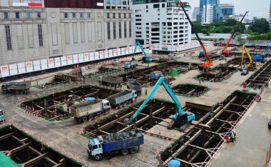 Asian labor people and thai labour workers use machine and heavy machinery working builder new structure tower high-rise building on scaffold at construction site at capital city in Bangkok, Thailand
