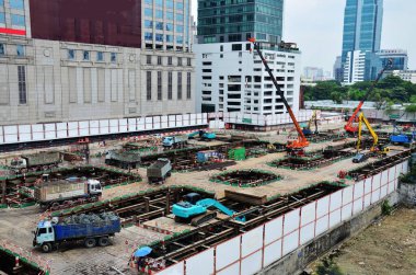 Asian labor people and thai labour workers use machine and heavy machinery working builder new structure tower high-rise building on scaffold at construction site at capital city in Bangkok, Thailand