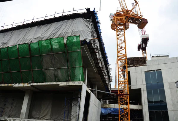 Asian labor people and thai labour workers use machine and heavy machinery working builder new structure tower high-rise building on scaffold at construction site at capital city in Bangkok, Thailand