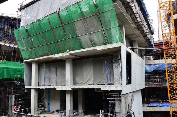 Asian labor people and thai labour workers use machine and heavy machinery working builder new structure tower high-rise building on scaffold at construction site at capital city in Bangkok, Thailand