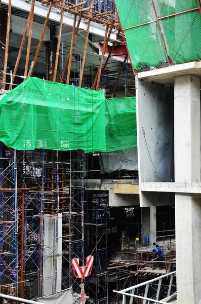 Asian labor people and thai labour workers use machine and heavy machinery working builder new structure tower high-rise building on scaffold at construction site at capital city in Bangkok, Thailand