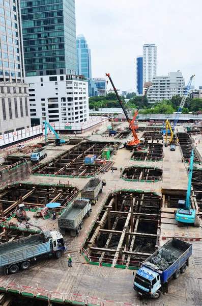 Asian labor people and thai labour workers use machine and heavy machinery working builder new structure tower high-rise building on scaffold at construction site at capital city in Bangkok, Thailand