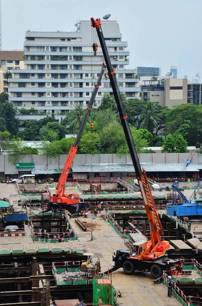 Asian labor people and thai labour workers use machine and heavy machinery working builder new structure tower high-rise building on scaffold at construction site at capital city in Bangkok, Thailand