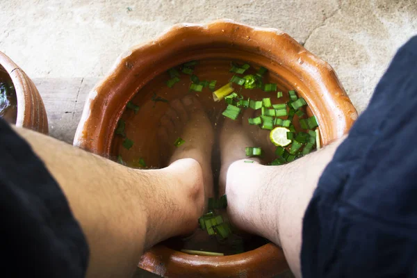 Thai men people sit relax and foot bath in basin with herb herbal before local spa massages thai style Koh Kret island in Pak Kret city at Nonthaburi, Thailand