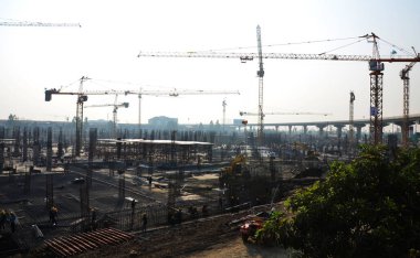 Asian labor people and thai labour workers use machine and heavy machinery working builder new structure tower high-rise building on scaffold at construction site at capital city in Bangkok, Thailand