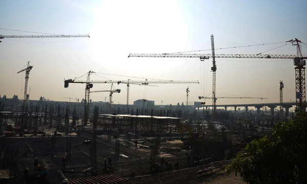 Asian labor people and thai labour workers use machine and heavy machinery working builder new structure tower high-rise building on scaffold at construction site at capital city in Bangkok, Thailand