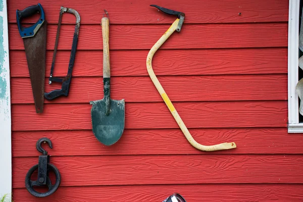 Tools and equipments farm gardening on red wooden wall of barn farmhouse for farmer use growing cultivating horticulture at meadow rural countryside in Nonthaburi, Thailand