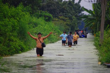 Tayland halkı, 20 Ekim 2011 'de Nonthaburi Tayland' da kırsal kesimde su taşkını yolunda yürürken, doğal afet kurbanları yolda yürüyorlar.