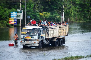 Taylandlı doğal afet kurbanları, 20 Ekim 2011 'de Nonthaburi Tayland' da kırsal kesimde su taşkınları kurtarma ve bağışta bulunurken, sokak arasında suda yürüyen araçları kullanıyorlar.