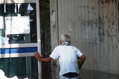 Taylandlı yaşlılar doğal afet kurbanları sokakta yürürken su taşkınları ve sel baskınları yolu kurtarmaya ve Tayland 'ın Nonthaburi kentindeki kırsal kırsal kesimde bağışlara yardım ediyor.