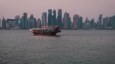 Doha 'nın ufuk çizgisi öğleden sonra çekimleri ön planda Katar bayraklarıyla ve arka planda Doha ufuk çizgisini gösteriyor.