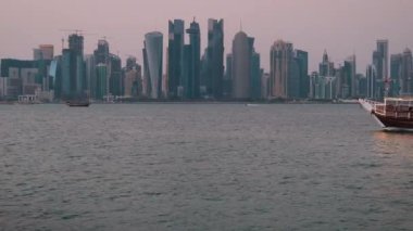 Doha, Katar ufuk çizgisi öğleden sonra çekimleri Dhows 'u Arap körfezinde Katar bayraklarıyla arka planda Doha ufuk çizgisini gösteriyor.