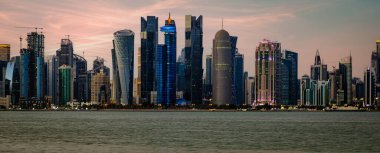 Corniche 'den Doha Skyline. Gündüz panoramik manzara. Batı Körfezi gökdelenlerini gösteriyor.
