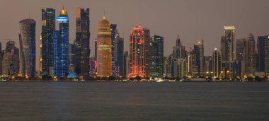 Doha Katar geceleri gökdelenlerin Arap körfezine yansıyan ışıklarını gösteriyor