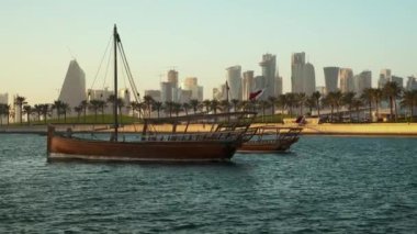 Doha 'nın ufuk çizgisi öğleden sonra çekimleri ön planda Katar bayraklarıyla ve arka planda Doha ufuk çizgisini gösteriyor.