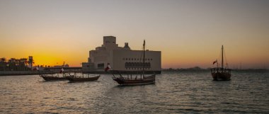 Doha 'daki İslam Sanatları Müzesi. Katar 'ın dış günbatımı görüntüleri müzenin eşsiz mimarisini ön planda Arap körfezinde eşarplarla gösteriyor.