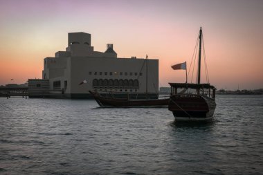 Doha 'daki İslam Sanatları Müzesi. Katar 'ın dış günbatımı görüntüleri müzenin eşsiz mimarisini ön planda Arap körfezinde eşarplarla gösteriyor.