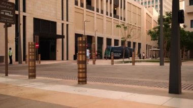 Doha 'daki Msheireb Şehir Merkezi, Katar öğleden sonra, binaların benzersiz mimarisini, yerel halk ve ziyaretçilerin yürüdüğü Modern Tram' ı gösteren bir çekim.