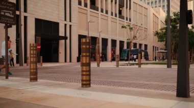 Doha 'daki Msheireb Şehir Merkezi, Katar öğleden sonra, binaların benzersiz mimarisini, yerel halk ve ziyaretçilerin yürüdüğü Modern Tram' ı gösteren bir çekim.