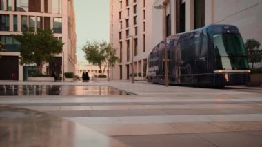 Doha 'daki Msheireb Downtown, öğleden sonra, binaların benzersiz mimarisini gösteren çekim, M7 (tasarımın yeni merkezi), Modern Tram ve yürüyen insanlar