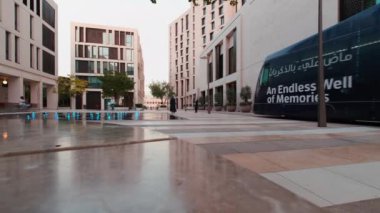 Doha 'daki Msheireb Downtown, öğleden sonra, binaların benzersiz mimarisini gösteren çekim, M7 (tasarımın yeni merkezi), Modern Tram ve yürüyen insanlar